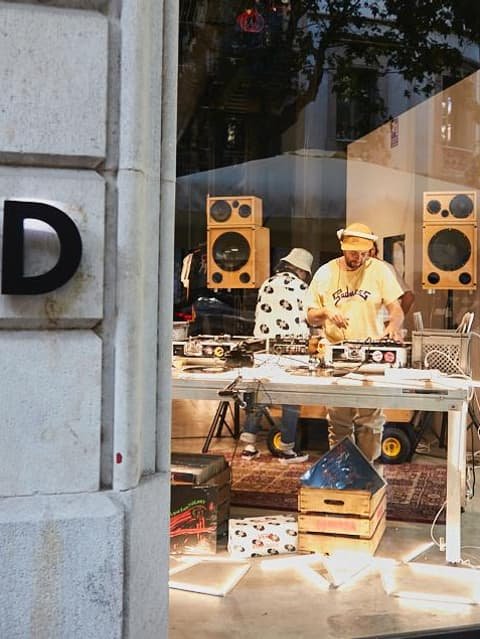 Djs pinchando en un local visto desde una ventana exterior